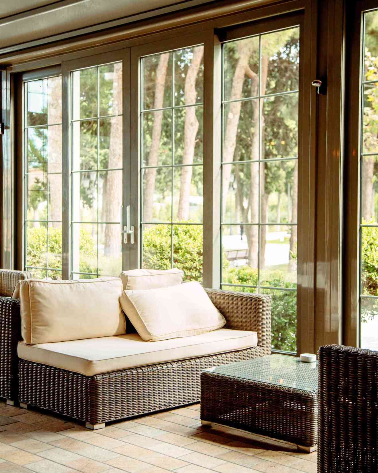 outdoor sofa with beige cushions coffee table front restaurant window