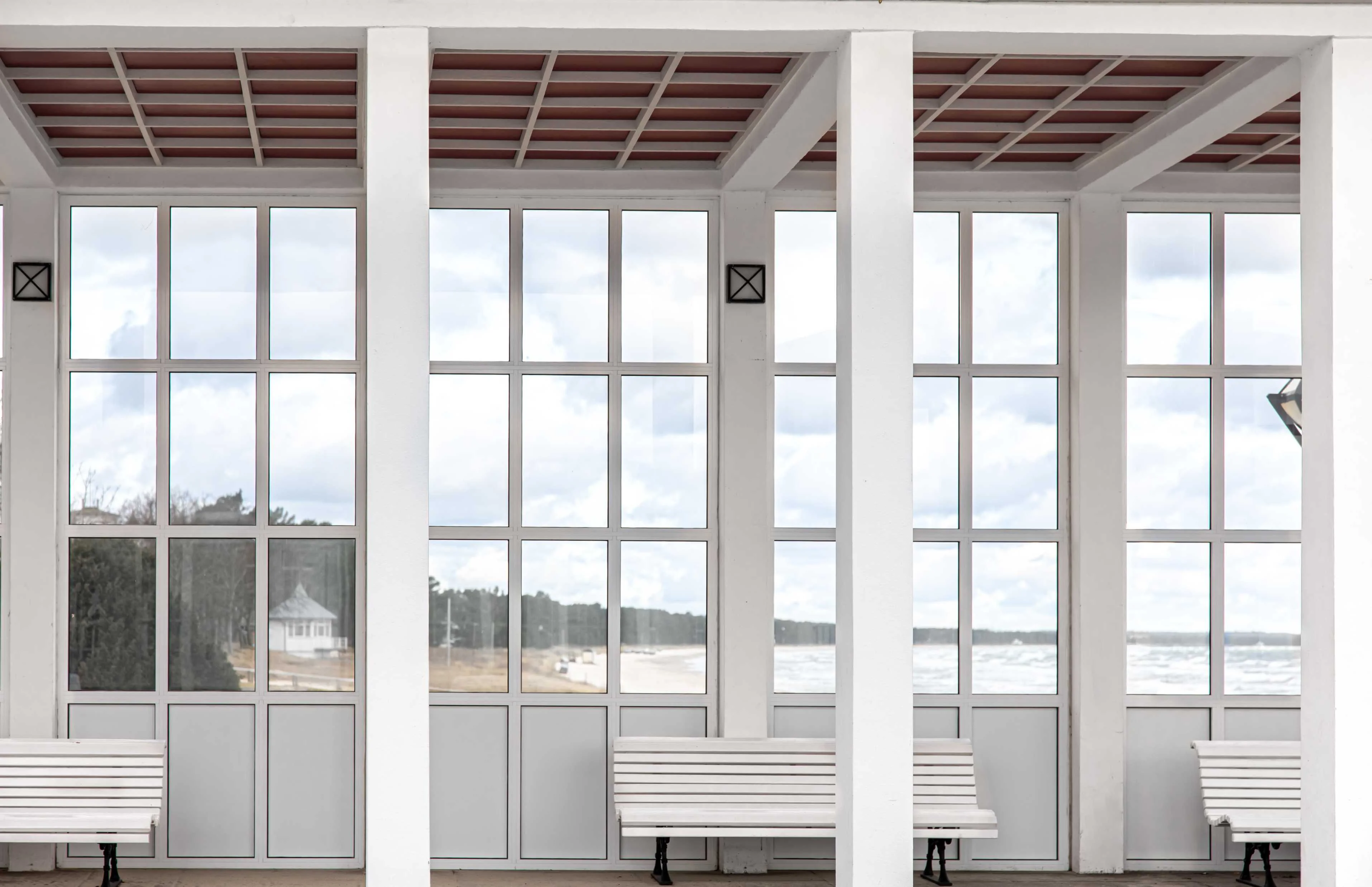 exterior white building with benches overlooking sea 1